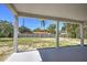 Covered patio overlooking a spacious yard featuring a white fence, trees, and a clear blue sky at 216 Homewood Dr, Sanford, FL 32773