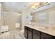 Modern bathroom with double sink vanity, shower, and tiled flooring at 2165 Leather Fern Dr, Ocoee, FL 34761