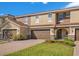 Townhouse exterior with brown garage doors, stone accents, and a well-maintained lawn at 2165 Leather Fern Dr, Ocoee, FL 34761