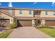 Multi-tone townhouse exterior with a two-car garage and a well-manicured lawn at 2165 Leather Fern Dr, Ocoee, FL 34761