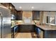 Well-equipped kitchen featuring stainless steel appliances, granite counters, and dark wood cabinets at 2165 Leather Fern Dr, Ocoee, FL 34761