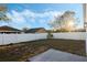 Large fenced backyard with small patch of grass, concrete patio, and view of neighboring homes at 237 Clarinet Way, Davenport, FL 33896