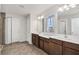 Bright bathroom featuring double sinks, tile floors, and a glass enclosed shower at 3005 Slough Creek Dr, Kissimmee, FL 34744