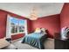 Red bedroom with a window view and dark wood dresser at 3005 Slough Creek Dr, Kissimmee, FL 34744