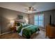 Cozy bedroom featuring a ceiling fan, a large window with blinds, and warm, neutral decor at 31707 Orange St, Sorrento, FL 32776