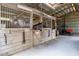 Spacious wooden horse stalls inside the barn, featuring metal barred windows at 31707 Orange St, Sorrento, FL 32776