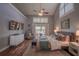 Bright main bedroom featuring tray ceilings, balcony doors, hardwood floors, and neutral-colored walls at 31707 Orange St, Sorrento, FL 32776