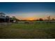 Picturesque sunset view of a lush, fenced pasture, ideal for equestrian activities at 31707 Orange St, Sorrento, FL 32776