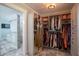 Spacious walk-in closet with custom shelving, a full-length mirror, and adjacent bathroom at 31707 Orange St, Sorrento, FL 32776