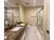 Bathroom with granite countertop, double sinks, large mirror, and a glass shower at 3191 Brasilia Ave, Kissimmee, FL 34747