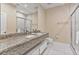 Bright bathroom features granite countertop, double sinks and modern white tile flooring at 3191 Brasilia Ave, Kissimmee, FL 34747