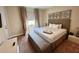 Serene bedroom with a plush king-size bed, tufted headboard, and soft neutral tones at 3191 Brasilia Ave, Kissimmee, FL 34747