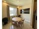 Cozy dining area features a round wood table, natural light from the window, and modern decor at 3191 Brasilia Ave, Kissimmee, FL 34747