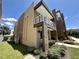 Low angle view of a two-story townhome with grass landscaping and a balcony at 3191 Brasilia Ave, Kissimmee, FL 34747