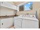 Bright laundry room with modern white appliances, utility sink, and ample storage space at 3191 Brasilia Ave, Kissimmee, FL 34747