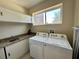 Convenient laundry room with a sink, granite countertops, and a modern washer and dryer set at 3191 Brasilia Ave, Kissimmee, FL 34747