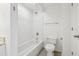 Bright bathroom featuring a white bathtub, toilet, and tiled walls at 322 E Central Blvd # 606, Orlando, FL 32801