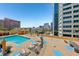 Pool with lounge chairs, plants, and city views at 322 E Central Blvd # 606, Orlando, FL 32801