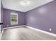 Bedroom with wood floors, window and neutral purple painted walls at 3357 Shalimar Cir, Deltona, FL 32738