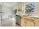 Functional kitchen with stainless steel dishwasher, vinyl floor, and sliding door to backyard at 3357 Shalimar Cir, Deltona, FL 32738