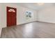 Inviting living room with durable wood-look flooring, neutral paint, and a red entry door at 3357 Shalimar Cir, Deltona, FL 32738