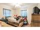 Bedroom featuring a bed, bedside table, and windows with blue curtains at 3708 Pipes O The Glen Way, Orlando, FL 32808