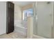 Bathroom featuring a soaking tub, separate shower, and storage cabinet at 4655 Ross Lanier Ln, Kissimmee, FL 34758