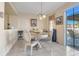 Bright dining room featuring a glass table, elegant chairs, and sliding doors leading to the patio at 4655 Ross Lanier Ln, Kissimmee, FL 34758