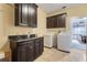 Practical laundry room equipped with modern appliances, dark cabinets, and ample counter space at 4655 Ross Lanier Ln, Kissimmee, FL 34758