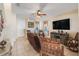 Comfortable living room featuring tile floors, a ceiling fan, a large TV, and inviting furnishings at 4655 Ross Lanier Ln, Kissimmee, FL 34758