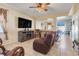 Comfortable living room featuring tile floors, a ceiling fan, a large TV, and cozy furnishings at 4655 Ross Lanier Ln, Kissimmee, FL 34758