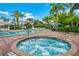 Inviting hot tub surrounded by brick and tile, complemented by lush landscaping at 4814 Cayview Ave # 407, Orlando, FL 32819