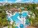 Aerial view of a resort-style pool with blue umbrellas and lounge chairs surrounded by palm trees and lush landscaping at 4814 Cayview Ave # 407, Orlando, FL 32819