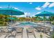 Leisure pool area with lounge chairs and bright blue umbrellas providing shade, ideal for relaxation at 4814 Cayview Ave # 407, Orlando, FL 32819