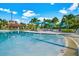 Inviting zero-entry pool with a nearby covered bar area, lounge chairs, and bright blue umbrellas surrounded by lush palm trees at 4814 Cayview Ave # 407, Orlando, FL 32819