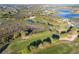 Aerial view of a golf course with water hazards and sand traps winding through a beautiful community at 5025 St Andrews Arc, Leesburg, FL 34748