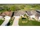 Beautiful aerial view of a home with a lush green lawn, palm trees, and a view of a nearby golf course at 5025 St Andrews Arc, Leesburg, FL 34748