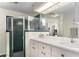 Functional bathroom featuring a dual sink vanity, glass enclosed shower, and ample lighting at 5025 St Andrews Arc, Leesburg, FL 34748