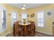 Cozy dining area with a wooden table set, bright yellow walls, and natural light from shuttered windows at 5025 St Andrews Arc, Leesburg, FL 34748