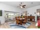 Open-concept dining room flowing into the living room, featuring wood floors and plenty of natural light at 5025 St Andrews Arc, Leesburg, FL 34748