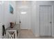 Welcoming entryway featuring a decorative table, neutral tile flooring, and a transom window above the door at 5025 St Andrews Arc, Leesburg, FL 34748