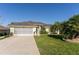 Charming single-story home with a well-manicured lawn, screened garage, and lush landscaping at 5025 St Andrews Arc, Leesburg, FL 34748