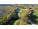 Scenic aerial view of a meticulously maintained golf course with water feature and manicured landscape at 5025 St Andrews Arc, Leesburg, FL 34748