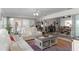 A sunlit living room features white leather seating and stylish decor, adjacent to the dining area at 5025 St Andrews Arc, Leesburg, FL 34748