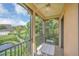 Balcony view of green trees and a peaceful pond with table and chairs at 506 Mirasol Cir # 202, Celebration, FL 34747