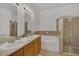 Elegant bathroom showcasing double sinks, a tub, and glass shower at 506 Mirasol Cir # 202, Celebration, FL 34747