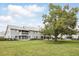 View of the back of a two-story townhome with white balconies and a large green lawn at 5336 White Cliff Ln # 6, Orlando, FL 32812