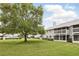 View of the back of a two-story townhome with white balconies and a large green lawn at 5336 White Cliff Ln # 6, Orlando, FL 32812