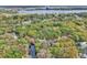 Stunning aerial perspective of a lakeside property surrounded by mature trees and a serene pond with lake access at 5374 Crooked Oak Cir, St Cloud, FL 34771