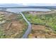 Picturesque aerial view featuring a tranquil canal waterway, lush vegetation, and a vast lake backdrop at 5374 Crooked Oak Cir, St Cloud, FL 34771